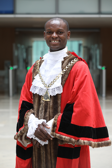 Man smiling in red and black cape